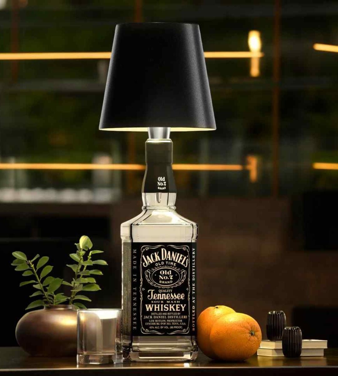 White bottle lamp on a square whiskey bottle on a bar table.