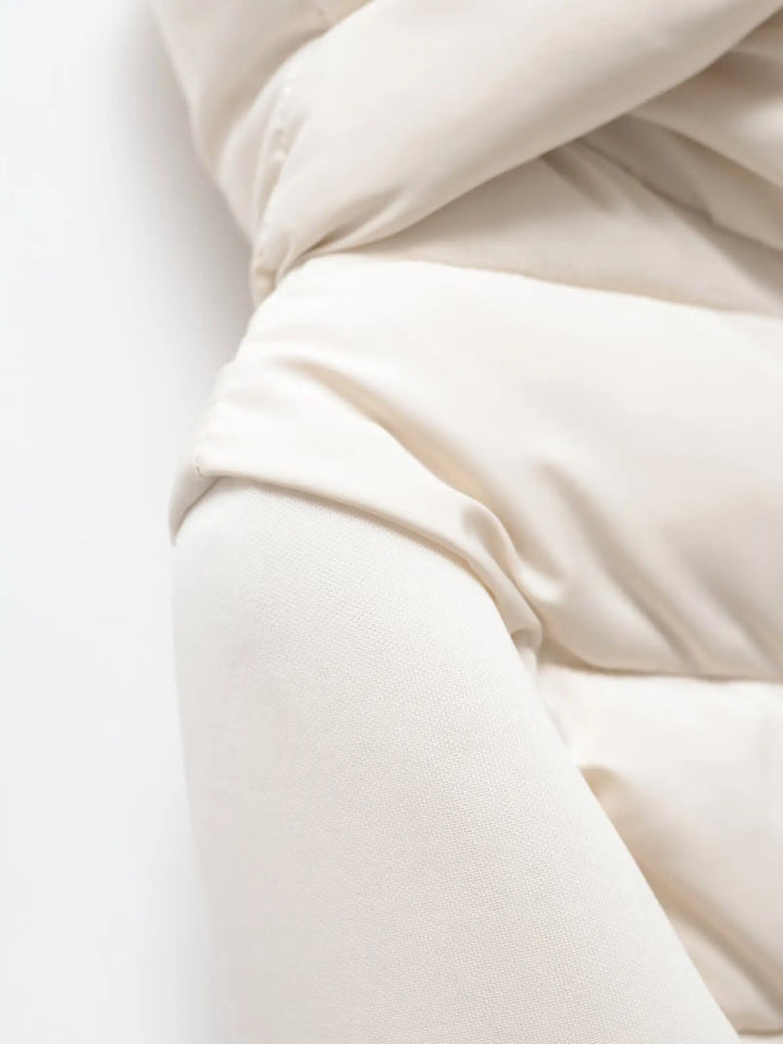 Women's white padded winter jacket detail showing the shoulder and smooth sleeve.