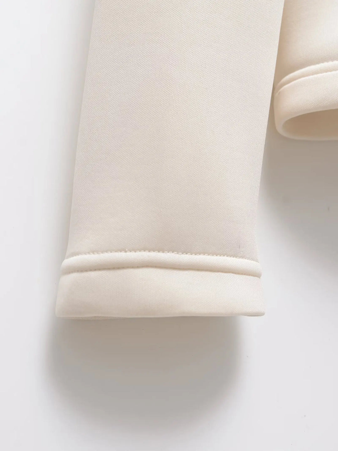 Women's white padded winter jacket detail of a sleeve cuff.