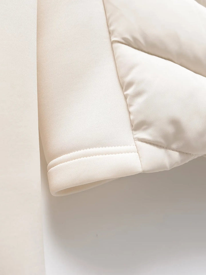 Women's white padded winter jacket detail of the sleeve cuff and side panel.
