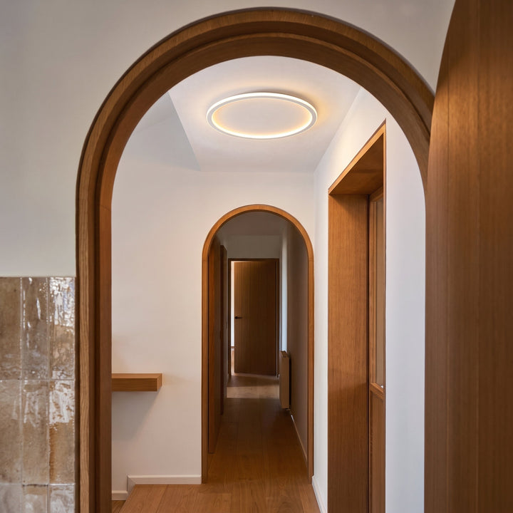 Another view of the glowing white ring ceiling light through a wooden arched doorway
