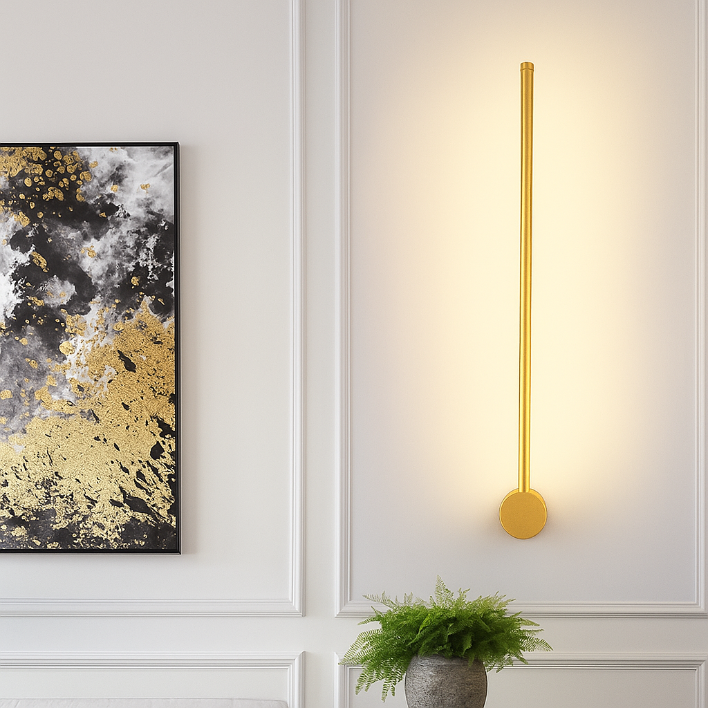 Gold linear wall light detail with a round base disc at the bottom.