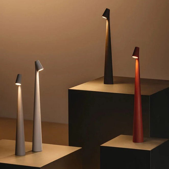 Detail of four lit slim rechargeable LED table lamps in taupe, cream, black and terracotta red.