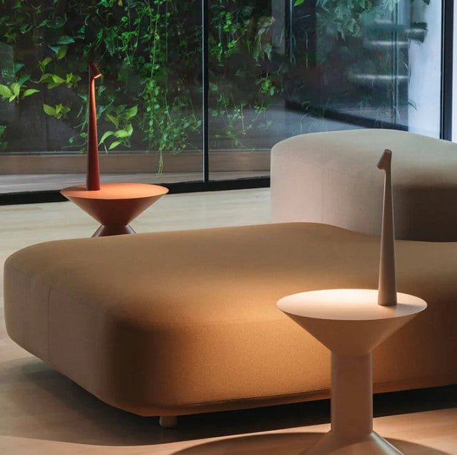 Another view of terracotta and cream rechargeable LED table lamps beside a sofa and green plants.
