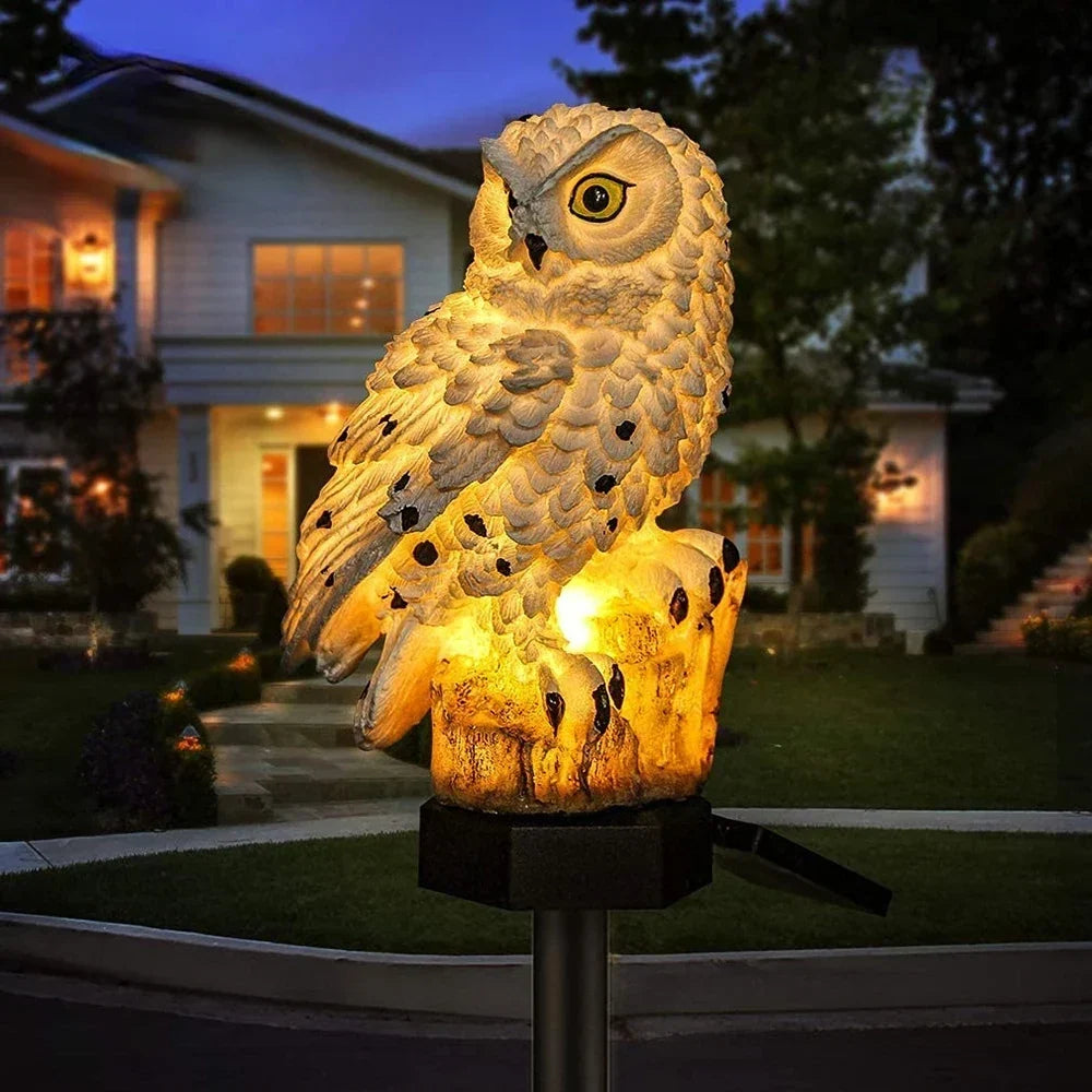 Single glowing white owl light with black speckles on a stake at dusk.