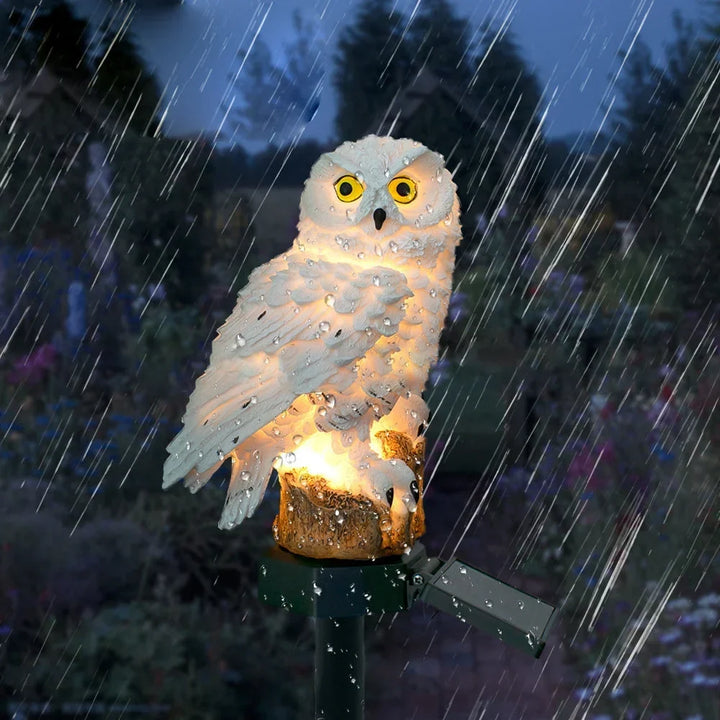 White owl light glowing in heavy rain with water drops on its body and solar panel.