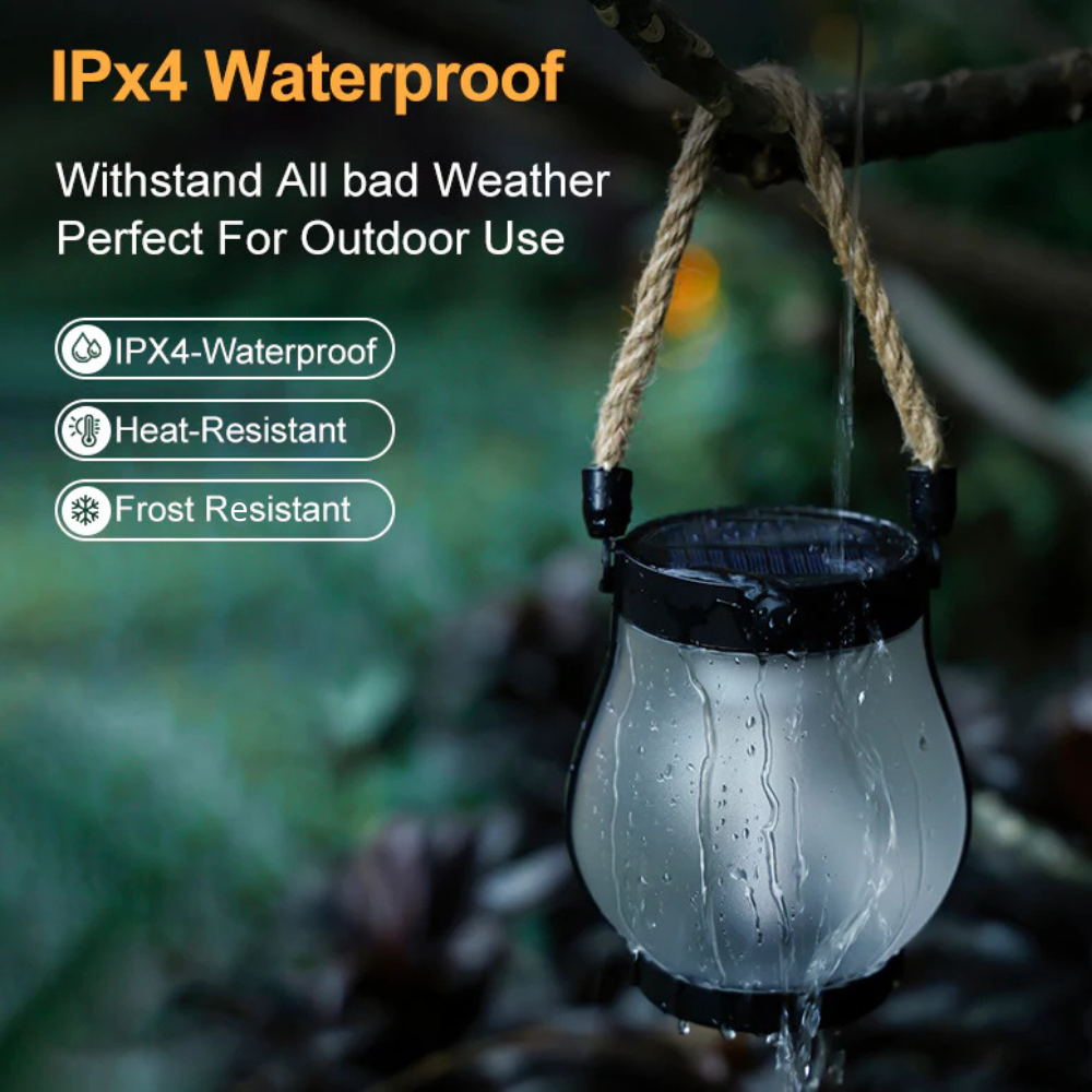 Solar lantern hanging by its rope handle in the rain with water streaming down the glass.