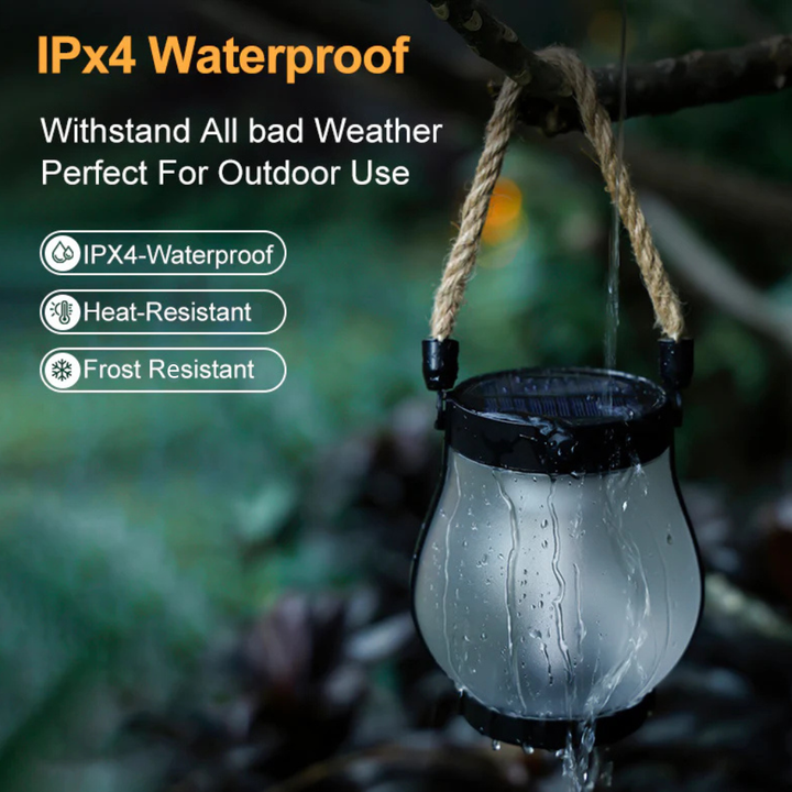 Solar lantern hanging by its rope handle in the rain with water streaming down the glass.