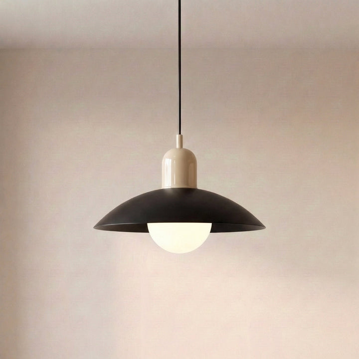 Close view of a beige Macaron Pendant Light with the bulb lit beneath the shade.