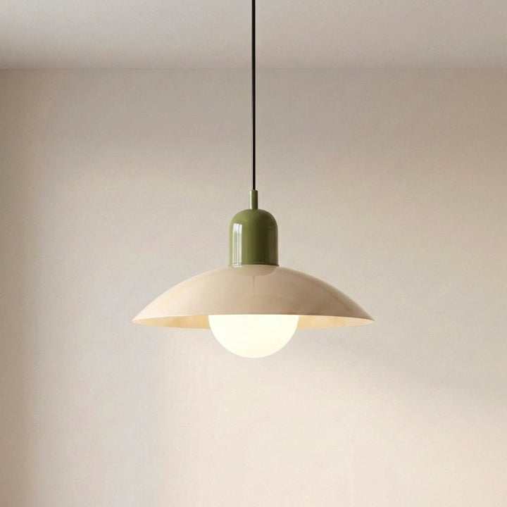 Beige Macaron Pendant Light against a wall with the bulb lit beneath the shade.