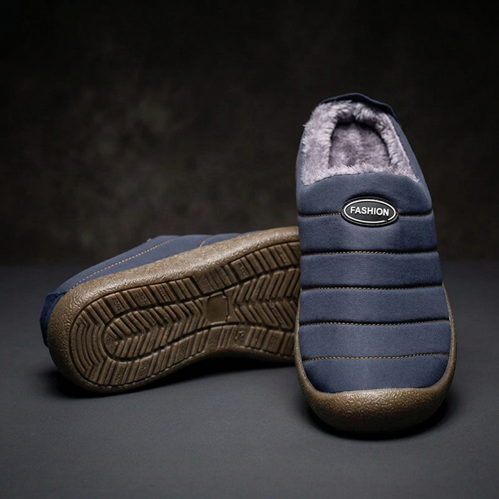 Navy blue slipper standing upright from the front beside its mate showing the patterned tread sole 18