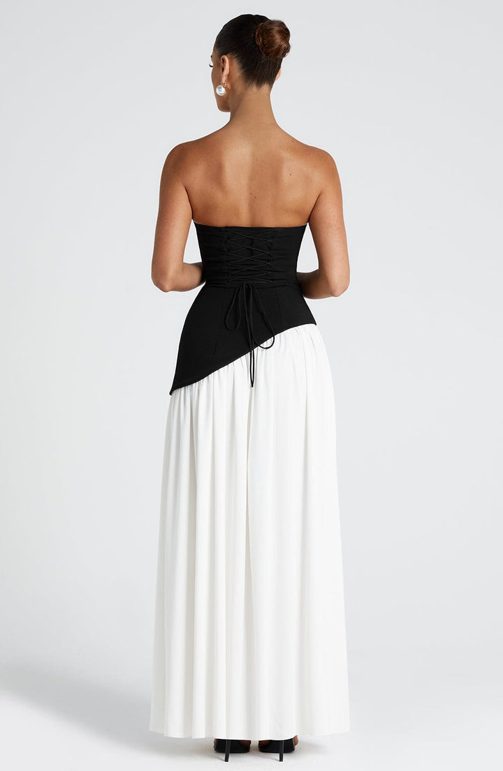 Back view of the black and white dress showing the black lace-up corset bodice and white gathered skirt.