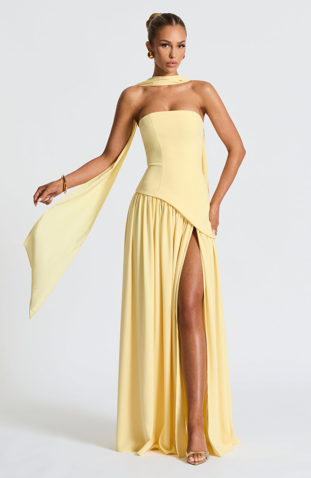 Pale yellow strapless maxi dress detail with the long scarf draped from the neck.