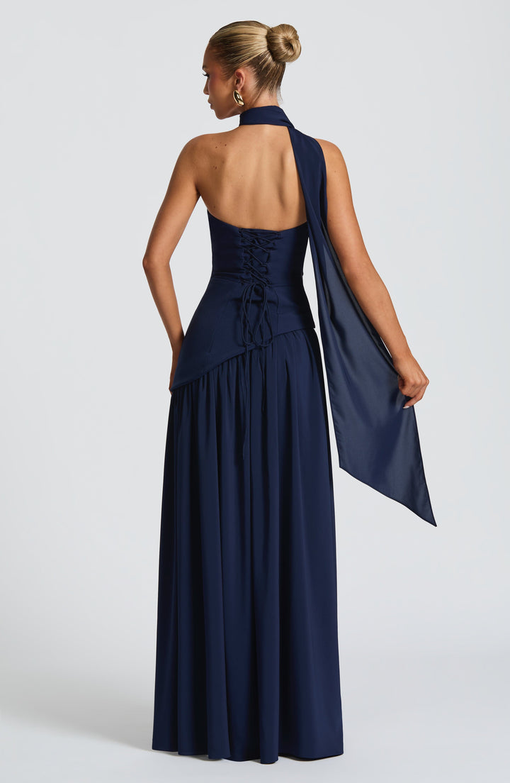Back view of the navy dress showing lace-up corset back and scarf draped over one shoulder.