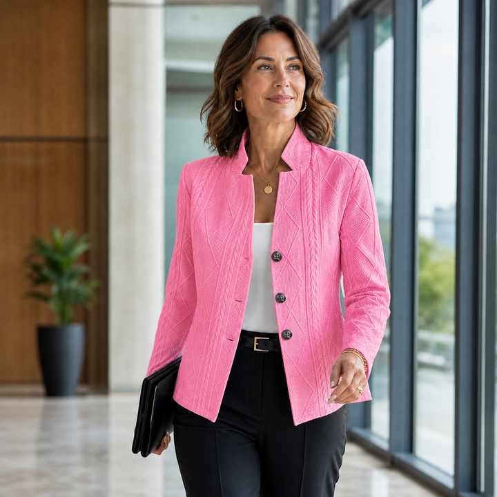 Bright pink textured blazer styled with a white top and black trousers, model walking in a sunlit corridor 8