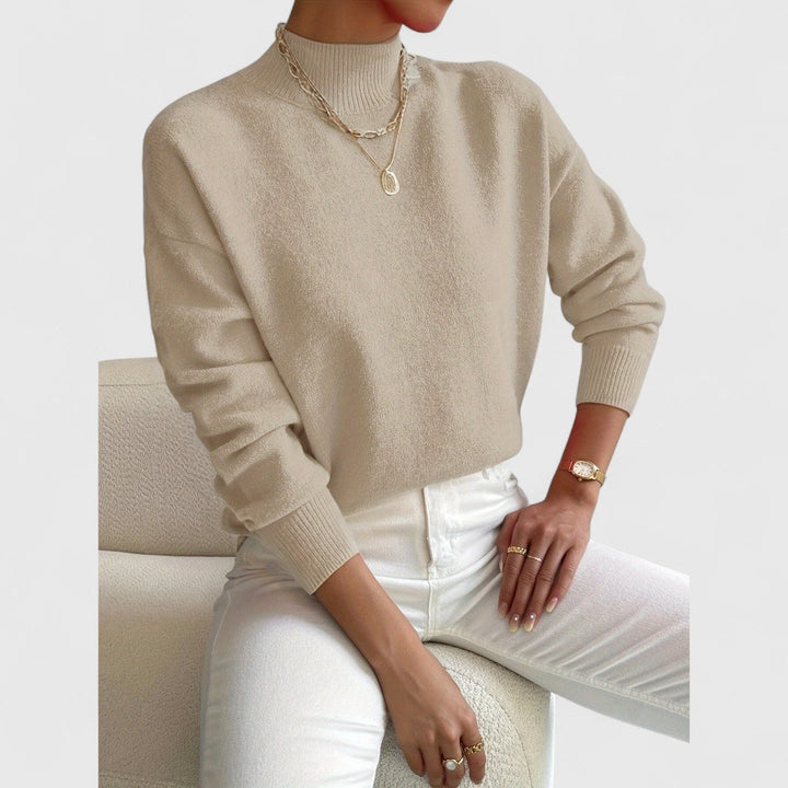 Women's sweater in beige showing the soft knit body, ribbed mock collar and cuffs.