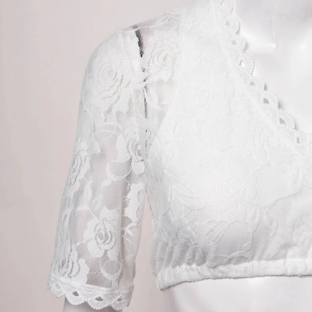 Detail of the shoulder and sleeve on a white lace dirndl blouse with rose pattern lace, scalloped eyelet trim and gathered hem.