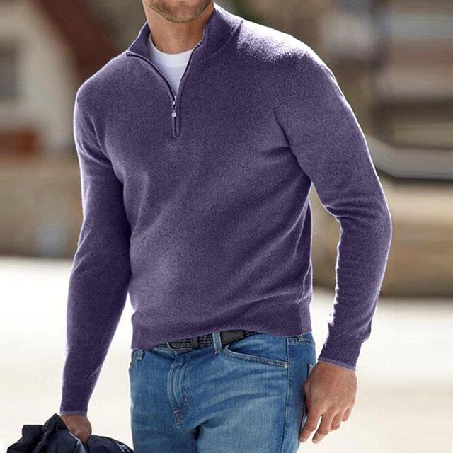 Man in a muted purple quarter-zip knit sweater and jeans, standing outdoors against a blurred street background.