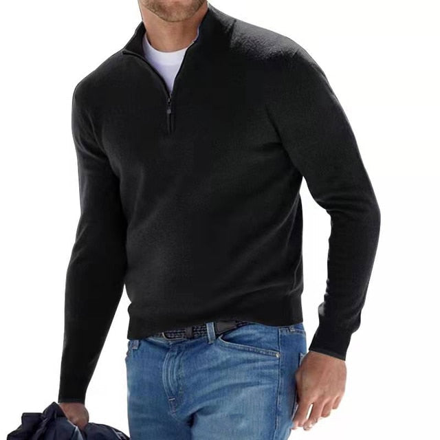 Man wearing the quarter-zip knit sweater in black over a white tee, paired with blue jeans and a belt.