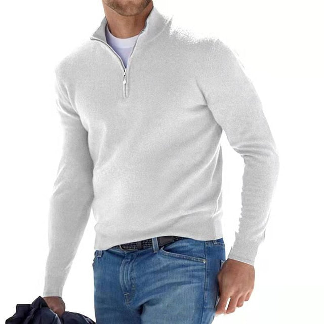 Man in a white quarter-zip knit sweater, layered over a white tee and worn with jeans.