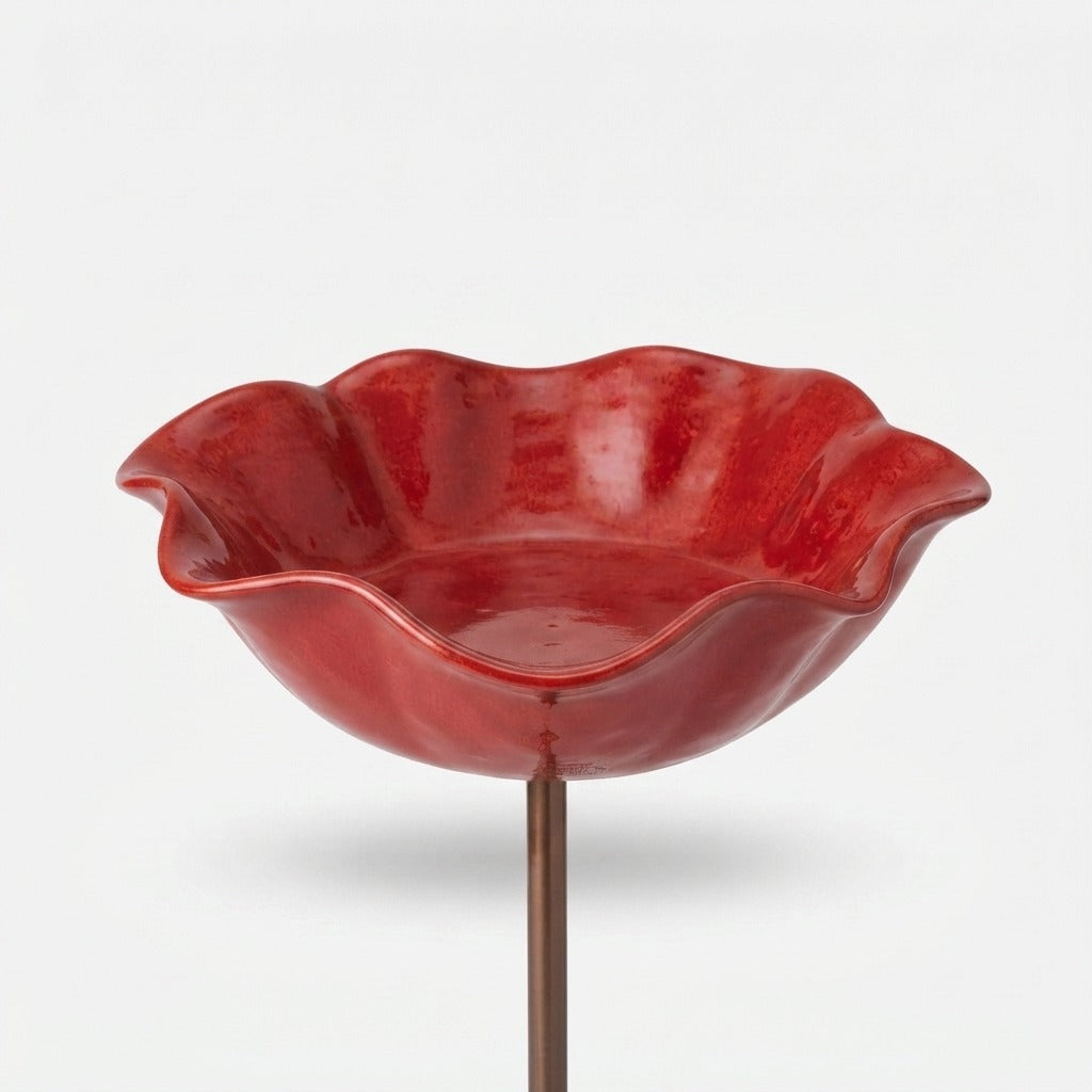 Red wavy-edged glazed bowl on a copper-toned stake.