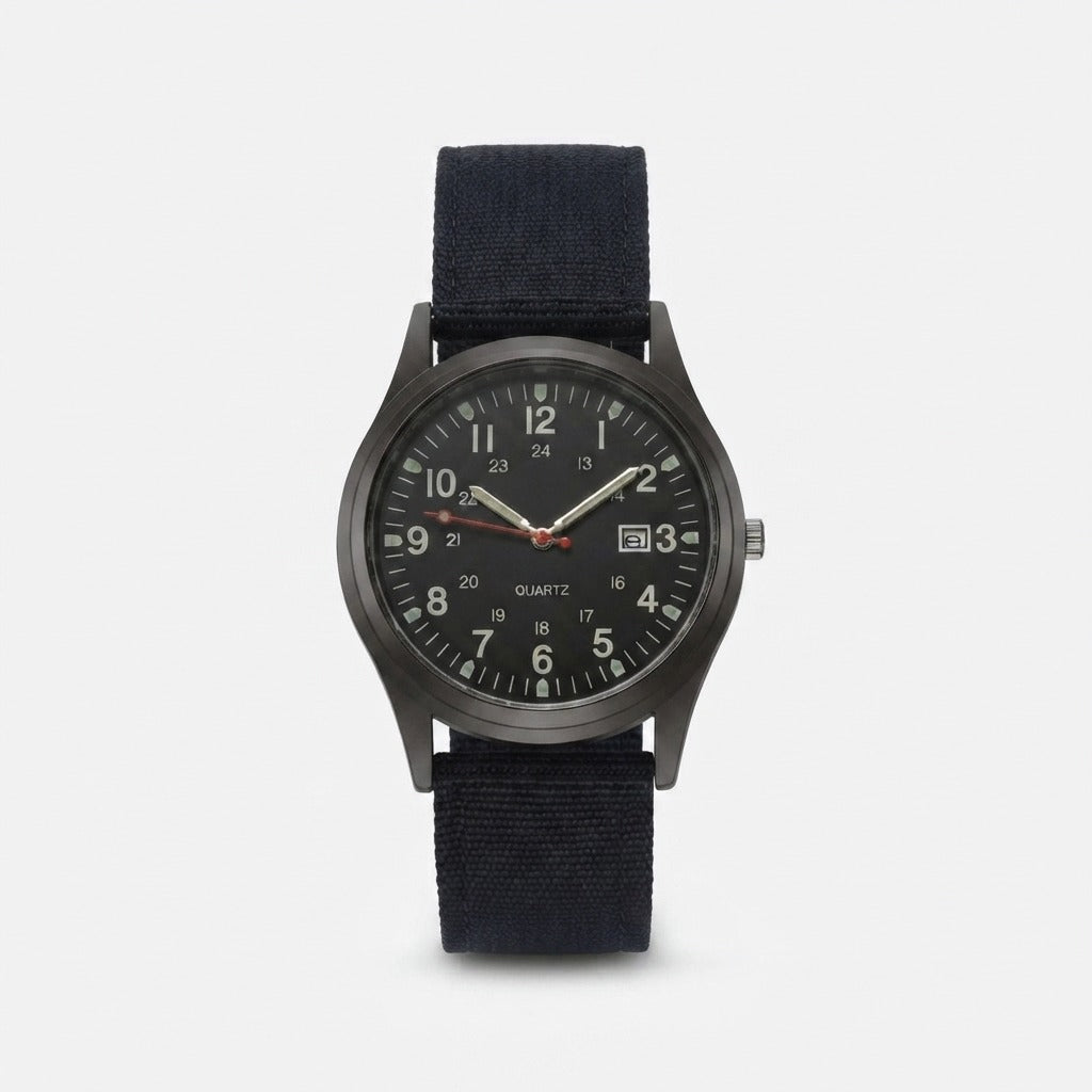 Black military watch with nylon strap, front view, showing the dark gunmetal case, luminous hands and date window.