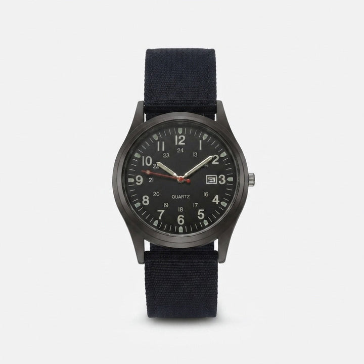 Black military watch with nylon strap, front view, showing the dark gunmetal case, luminous hands and date window.