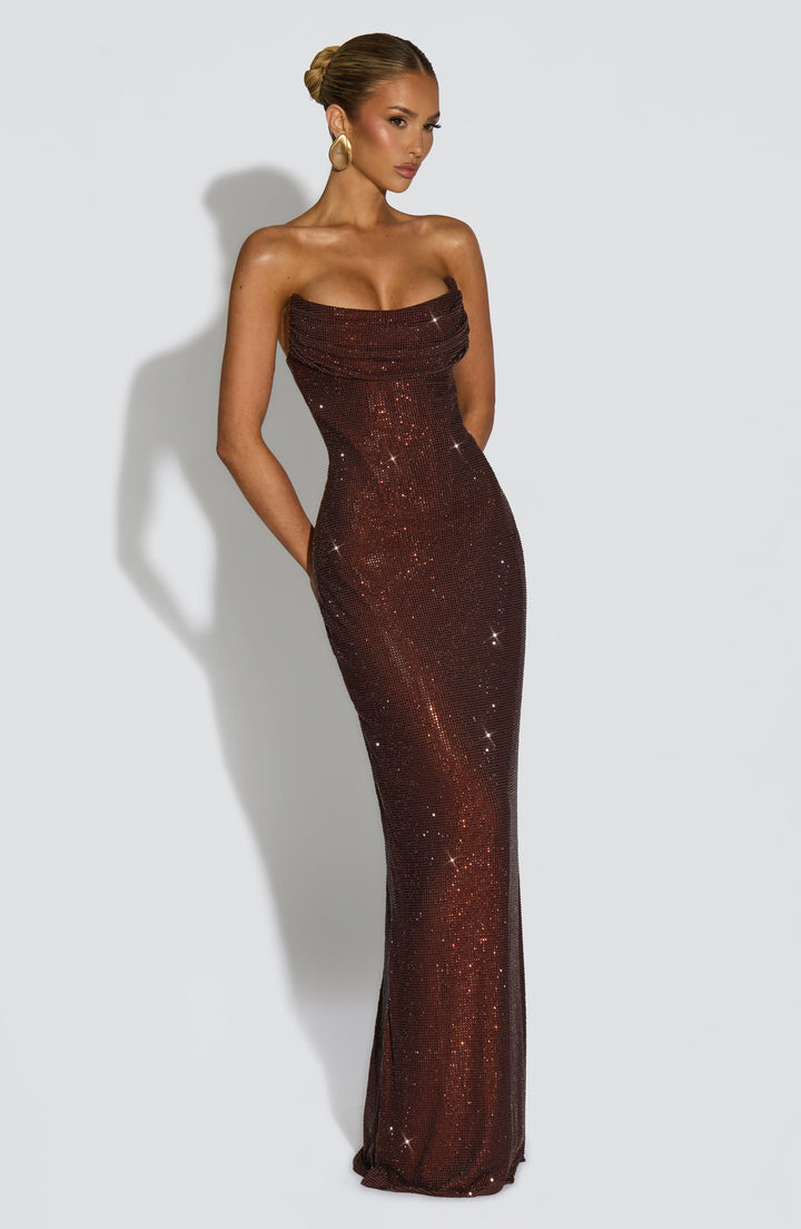 Angled view of the brown dress with hands hidden behind, showing the fitted silhouette and floor-length skirt 12
