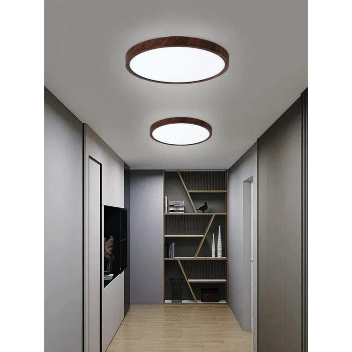 Two walnut-finish round ceiling lights, one larger and one smaller, in a gray hallway.