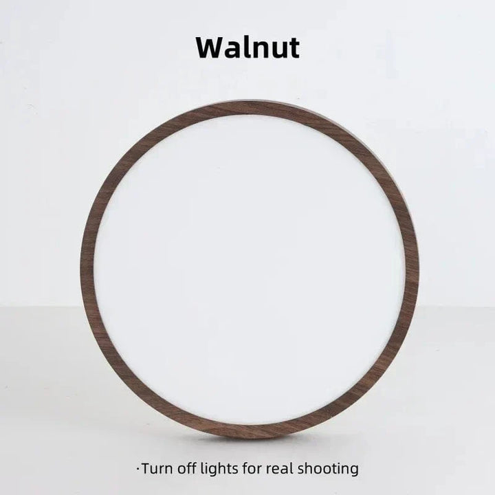 Front view of the round walnut-finish light switched off against a plain light background.