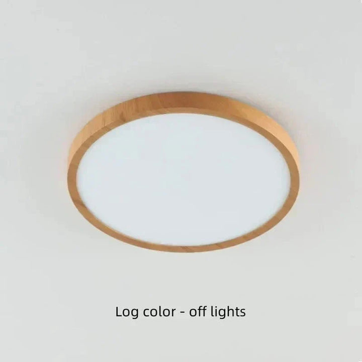 Light log-color wood-finish round light switched off on a pale ceiling.