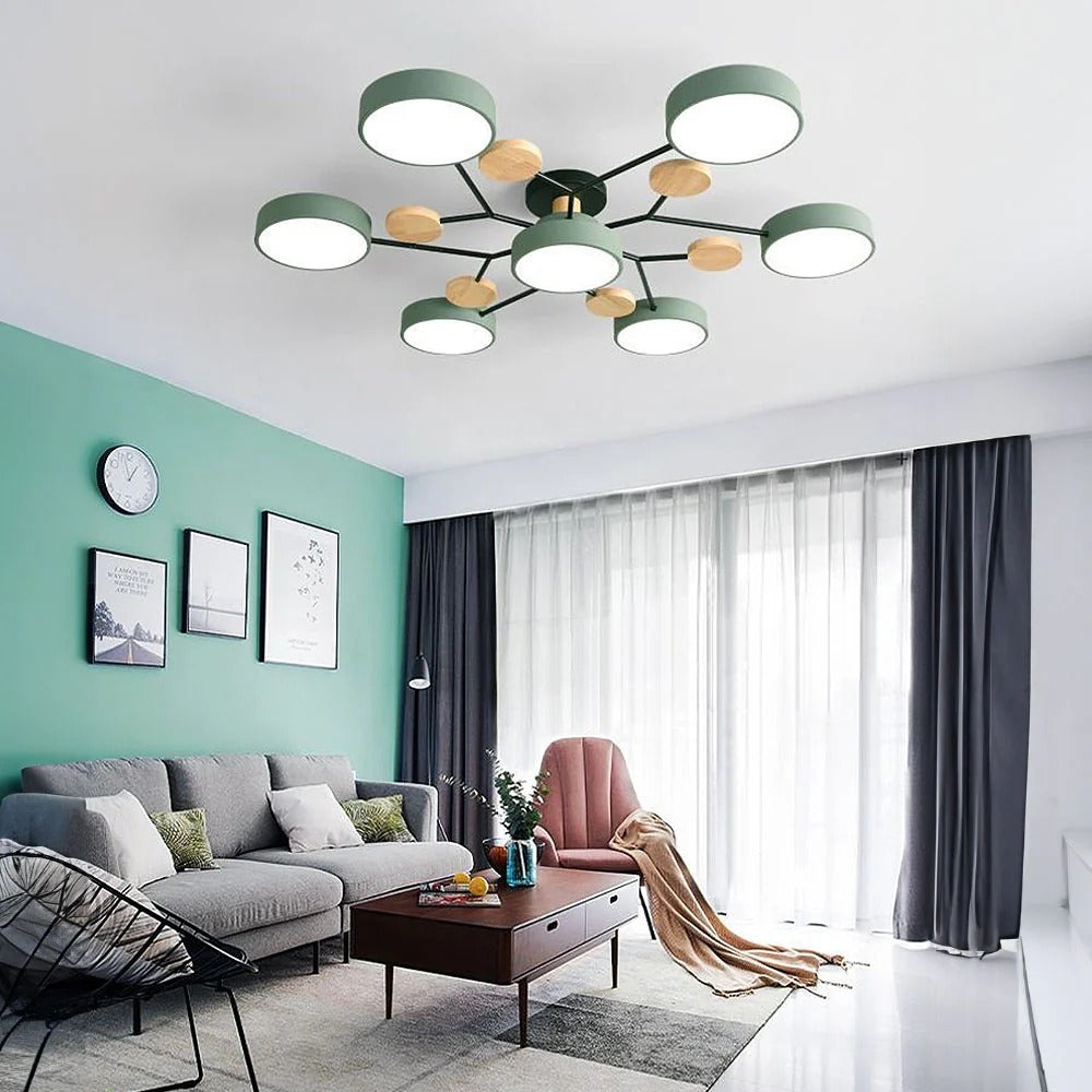 Green seven-light chandelier in a living room with a teal accent wall, gray sofa, pink armchair and sheer curtains. 11