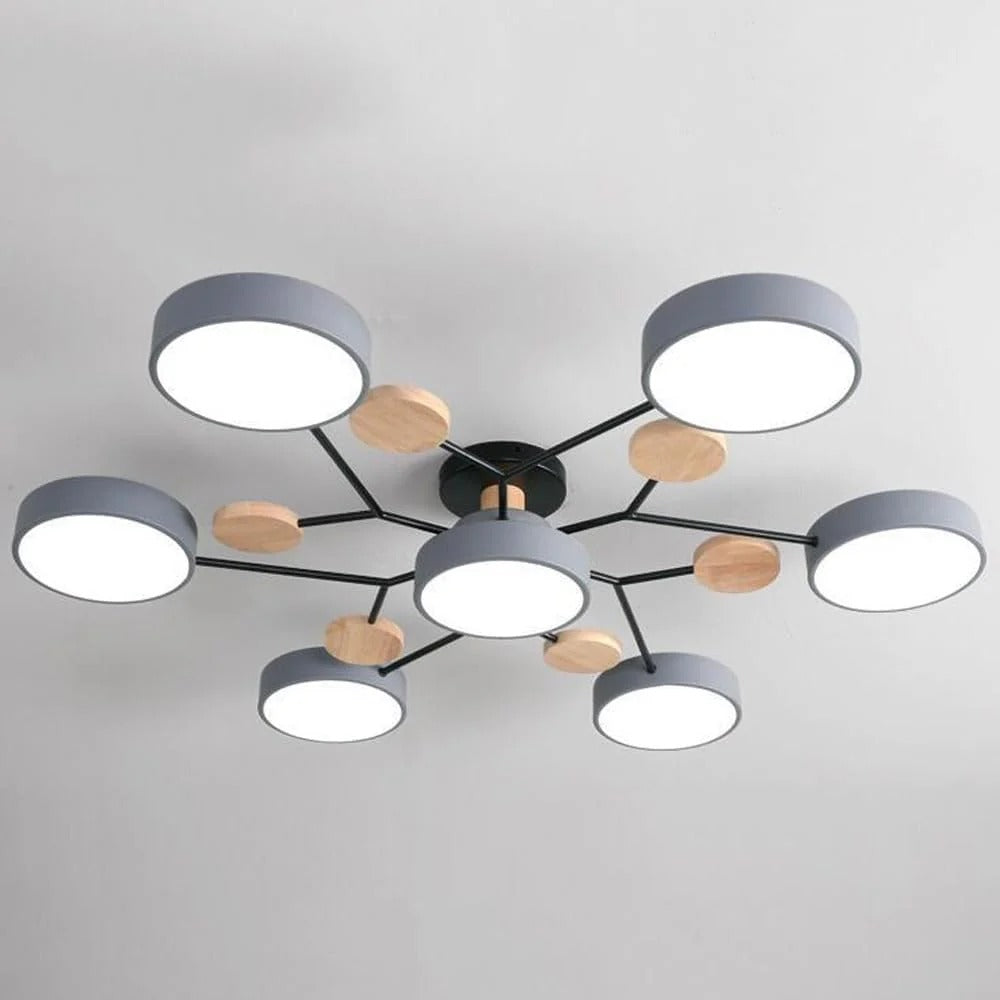 Close view of the gray seven-light chandelier showing its round shades, black branching arms and wooden discs on a gray ceiling. 12
