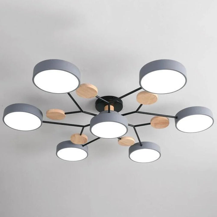 Close view of the gray seven-light chandelier showing its round shades, black branching arms and wooden discs on a gray ceiling. 12