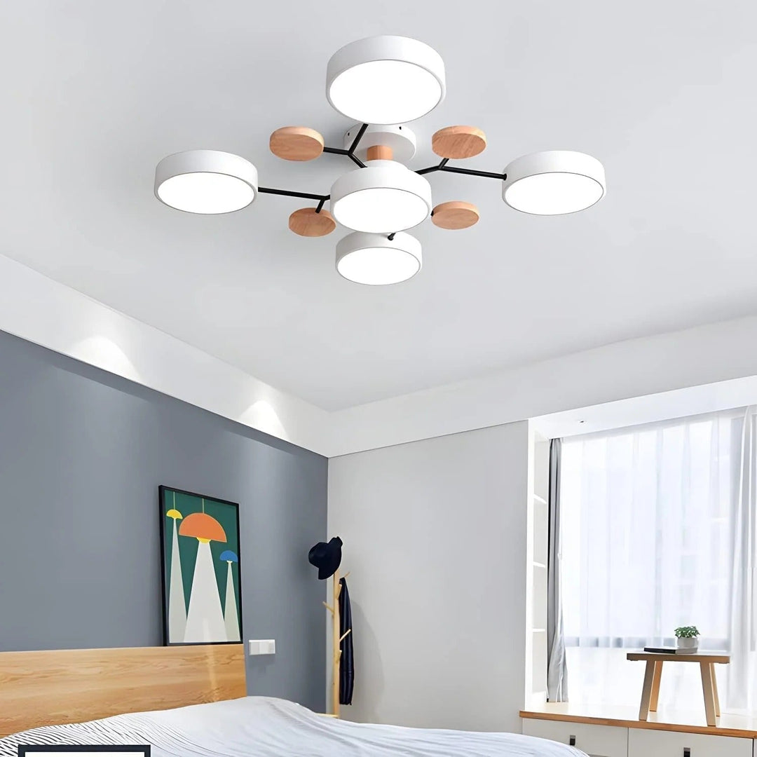 White five-light chandelier in a bedroom with a blue-gray wall, wooden bed frame, framed print and sheer curtains. 16