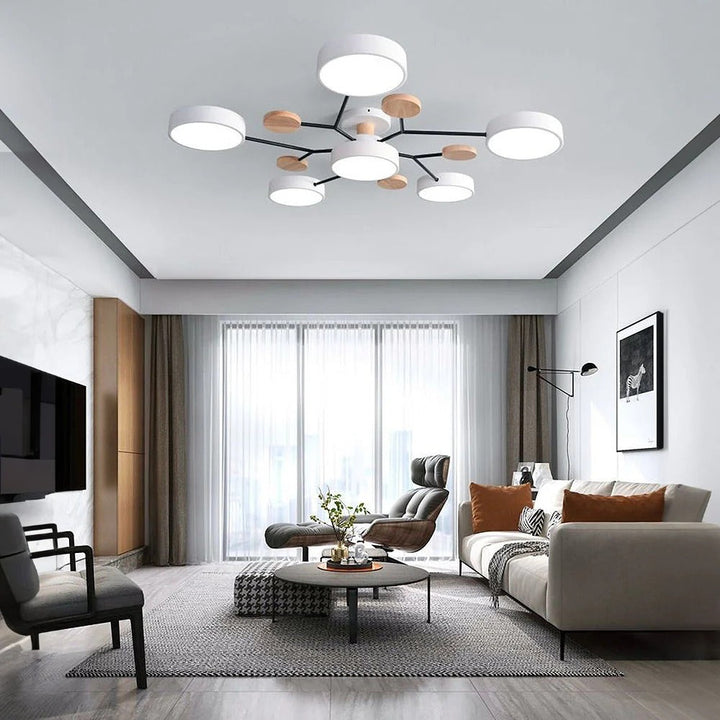 White seven-light chandelier in a modern living room with a gray sofa, leather lounge chair and wall-mounted TV. 17