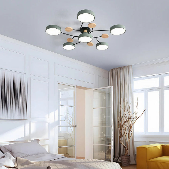 Green seven-light ceiling fixture hanging in a bright bedroom with white paneled walls, a glass door and a yellow armchair. 2
