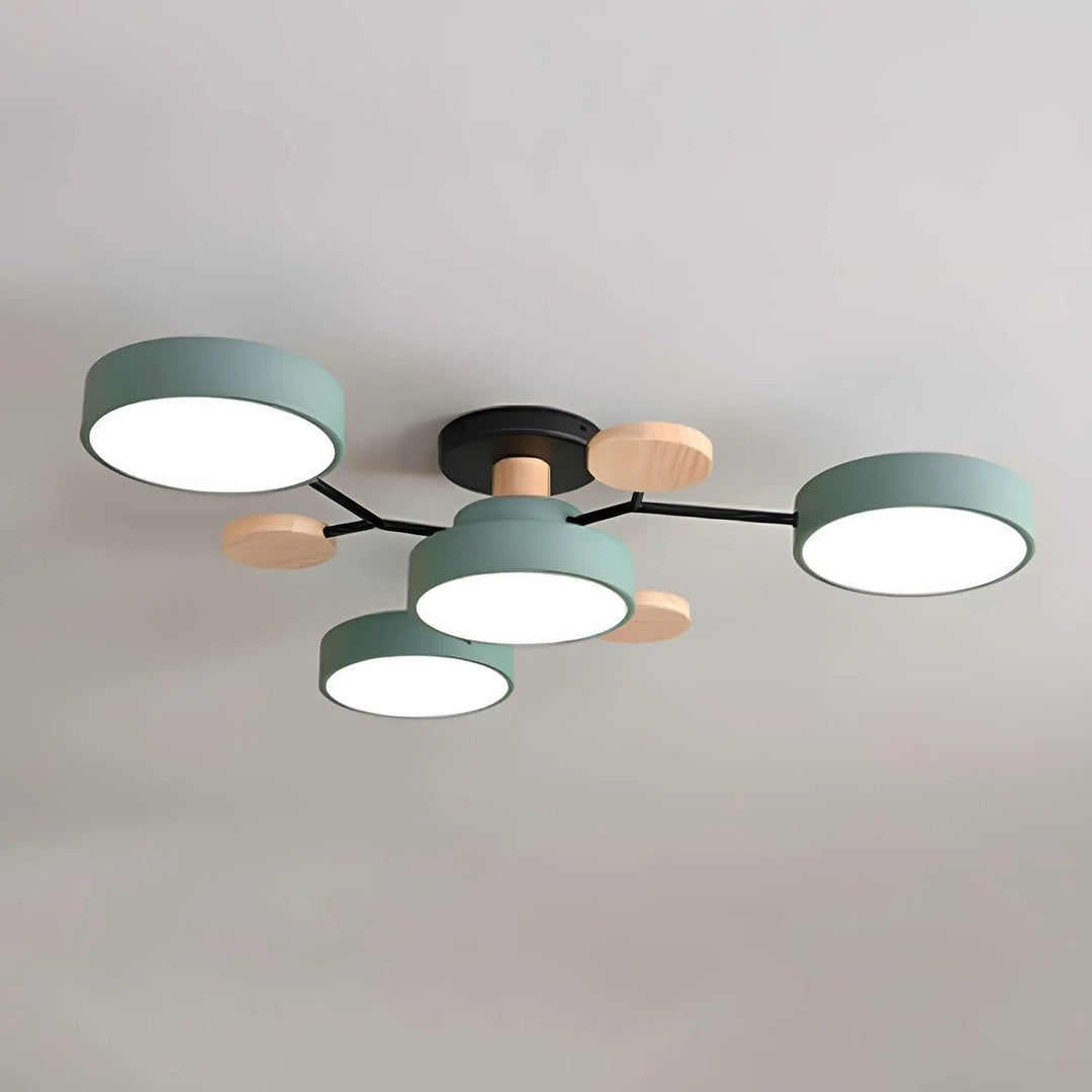 Green four-drum ceiling light with black arms and round wood discs, shown close up against a plain gray ceiling. 22