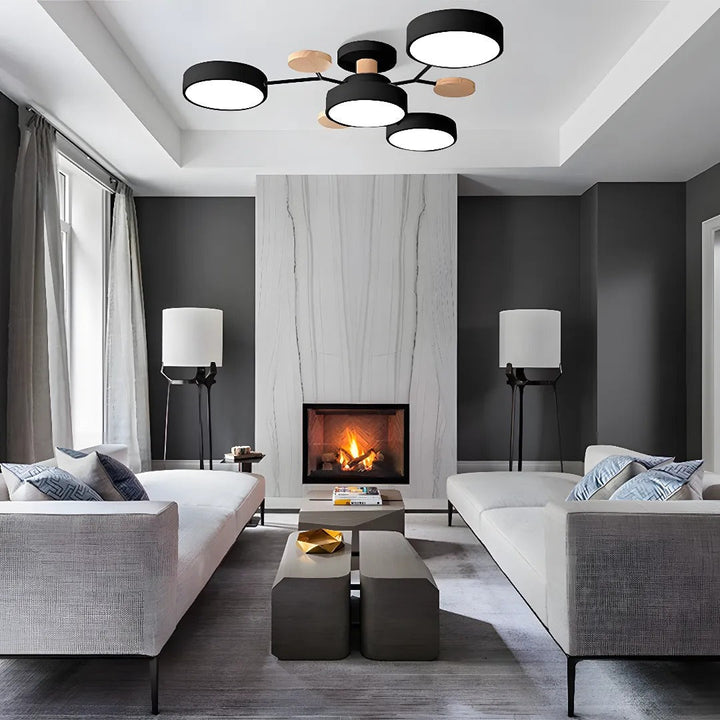 Black four-drum ceiling light in a tray ceiling above a gray living room with two white sofas and a fireplace. 24