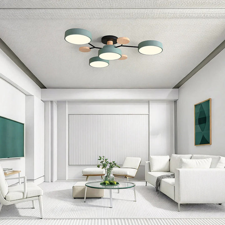 Green four-drum ceiling light with wood discs above a bright white living room with a glass coffee table and green wall art. 38