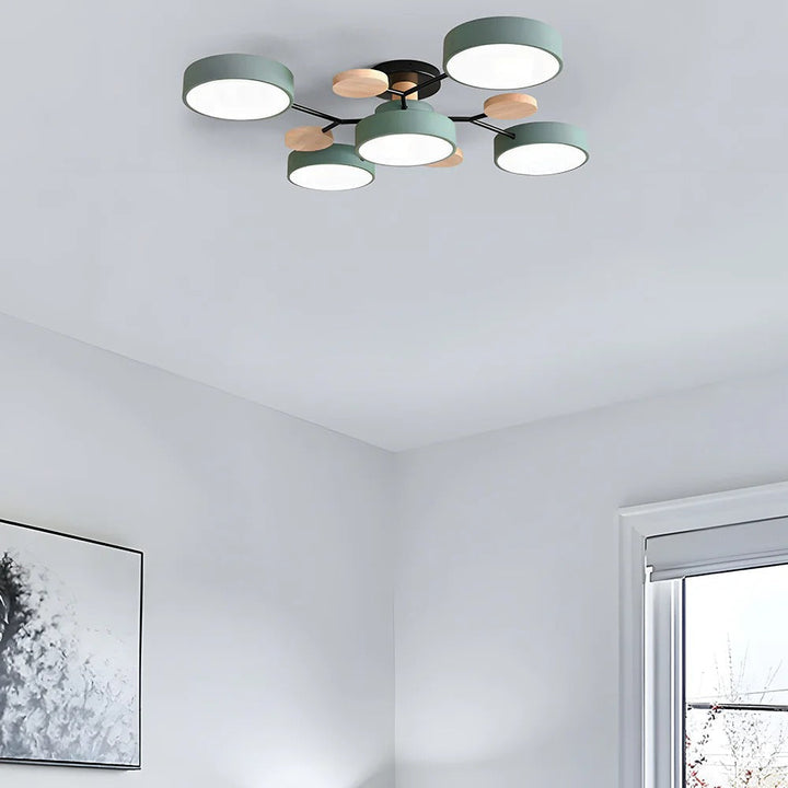 Green five-shade ceiling light with wooden accents mounted in a corner of a white room, near a window and framed artwork. 42