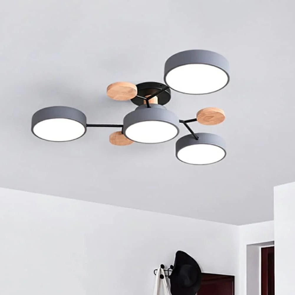 Gray four-light version with wooden discs and black arms, installed on a white ceiling above a coat rack. 6