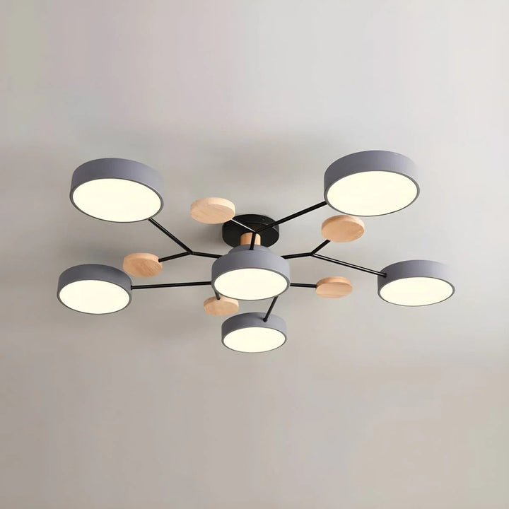 Gray six-light chandelier with black arms and wooden discs seen from below against a plain light ceiling. 9