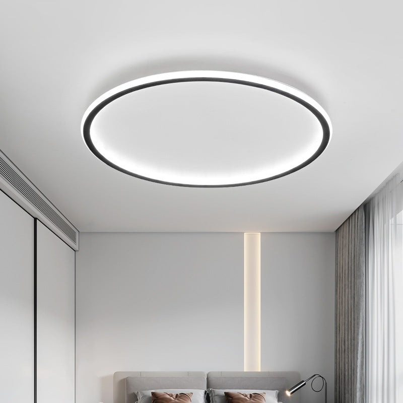 Black ring ceiling light another view in cool white above a gray bed with gray curtains and a vertical strip light on the wall.
