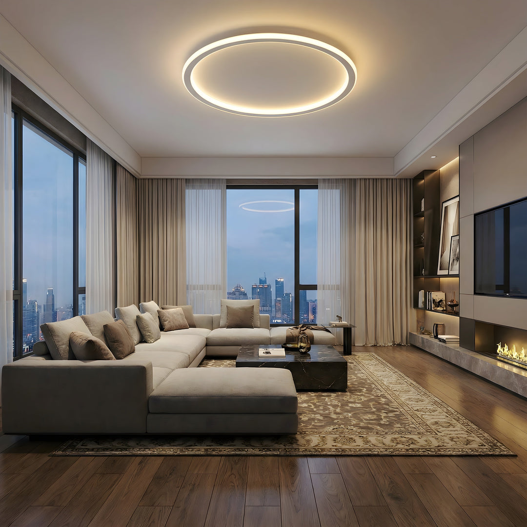 White ring ceiling light another view in a spacious evening living room with a large sectional, fireplace, and city view.
