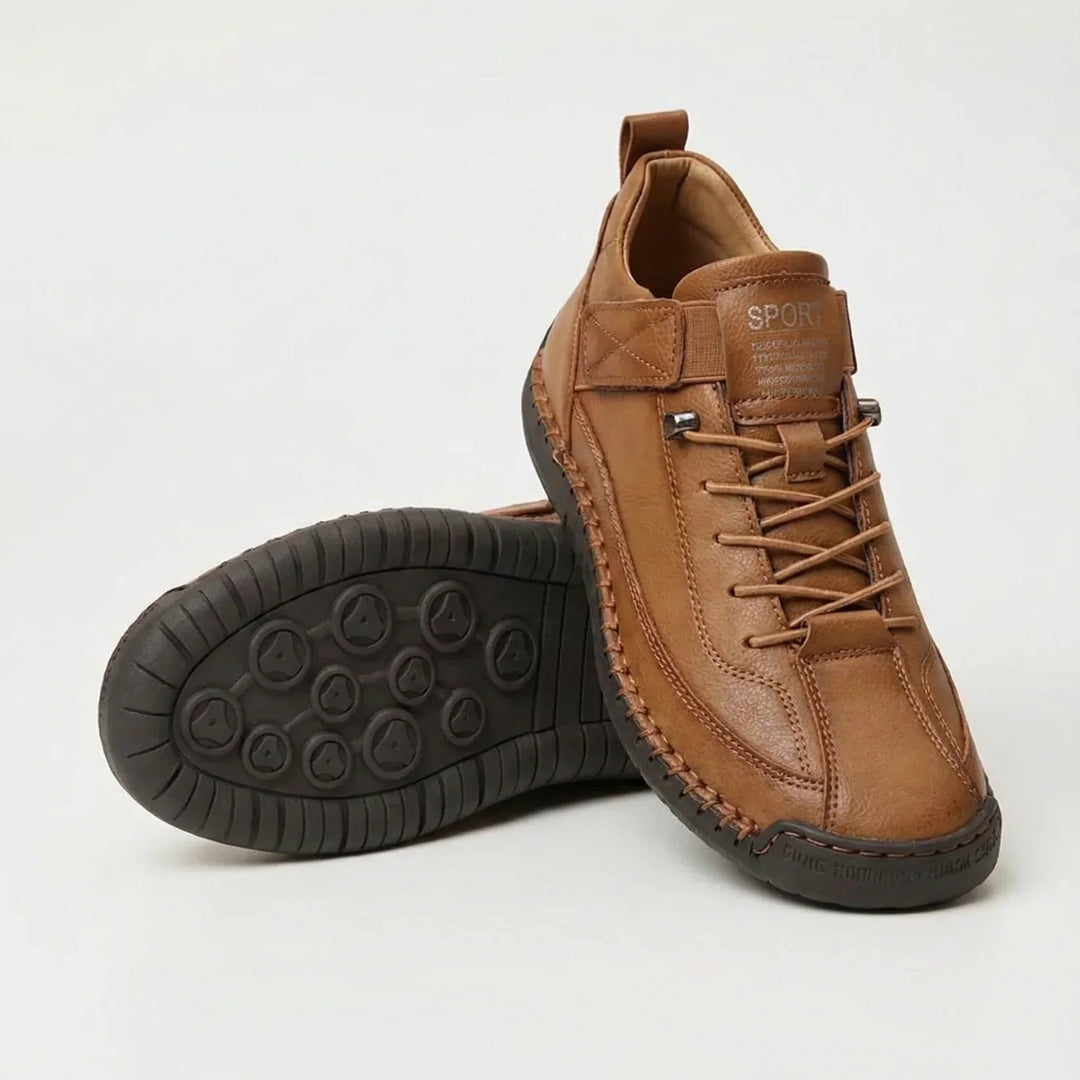 Tan brown leather-look sneakers with contrast stitching, one shoe upright and one showing the dark tread sole 4
