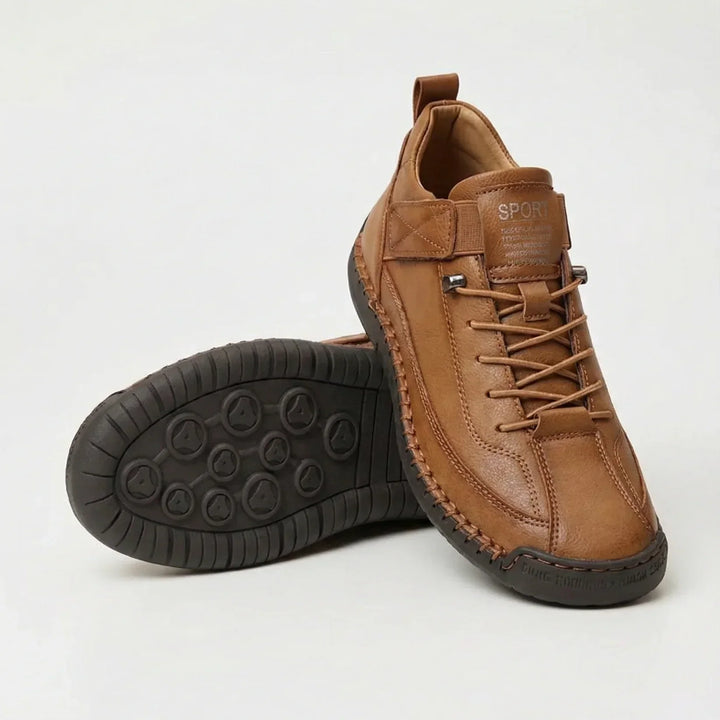 Tan brown leather-look sneakers with contrast stitching, one shoe upright and one showing the dark tread sole 4
