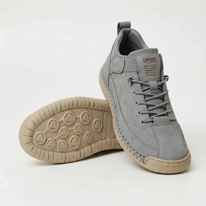 Light gray sneakers with matching elastic laces and a beige sole, one shoe upright and one showing the dotted tread 8