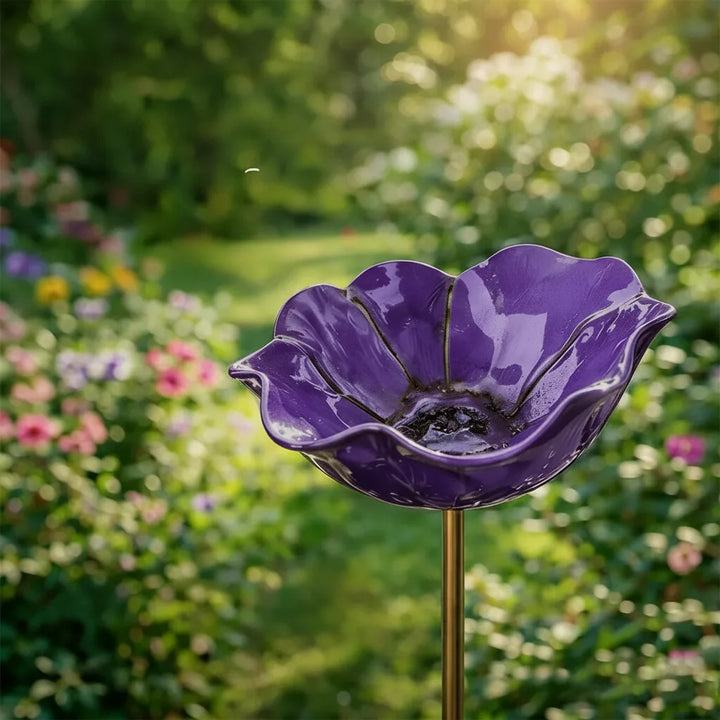 Deep purple petal-shaped bird bath on a stake.