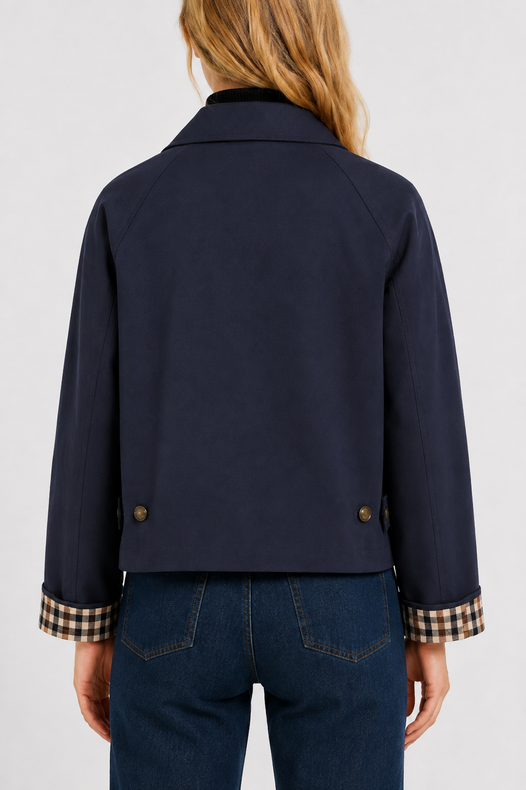 Women's navy blue lightweight jacket, back view with two buttoned waist tabs and turned-up gingham cuffs.